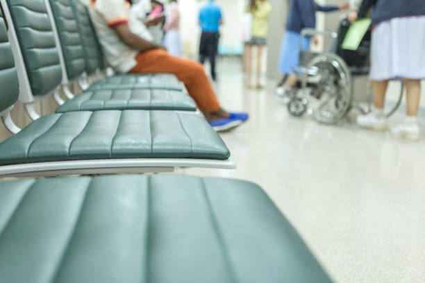 patients waiting in hospital waiting room, sitting on bench