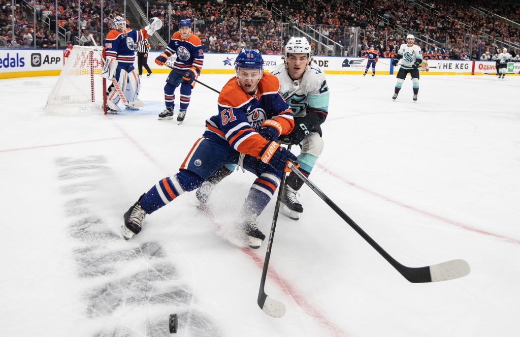 Seattle Kraken's Eeli Tolvanen (20) and Edmonton Oilers' Troy Stecher (51) battle for the puck during first period NHL pre-season action in Edmonton on Saturday, September 28, 2024