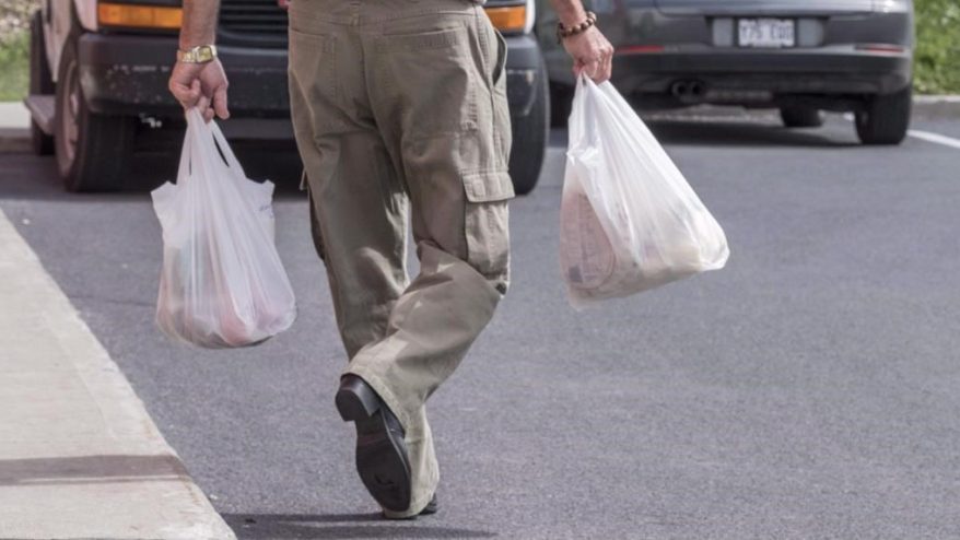 Man walking with two plastic bags