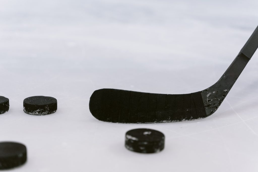 Hockey stick and pucks on the ice.